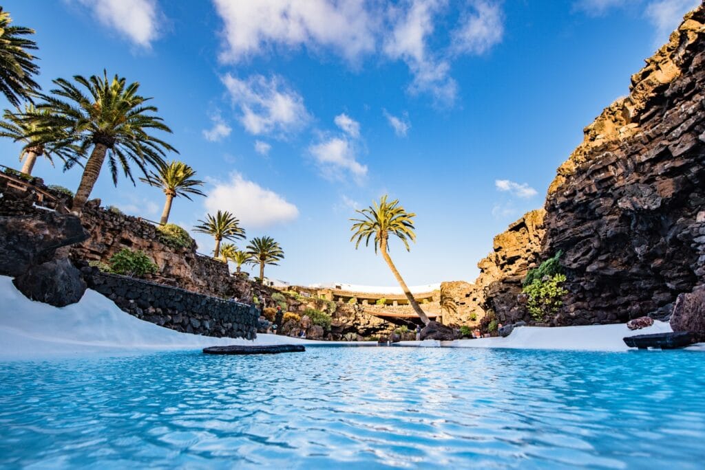 La piscina turquesa de los Jameos del Agua, entre palmeras y paredes de lava